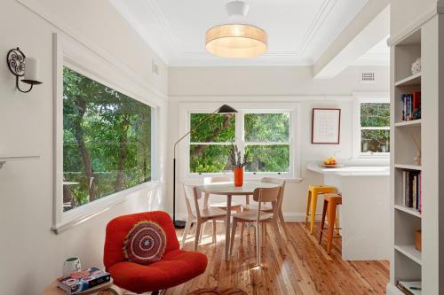 a dining room with a table and chairs and windows at Cooinda Mountain Retreat in Blackheath