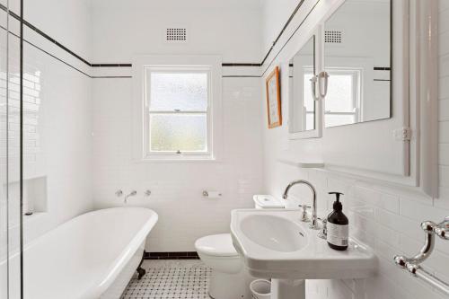 a white bathroom with a tub sink and a toilet at Cooinda Mountain Retreat in Blackheath