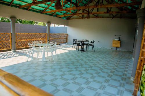a patio with tables and chairs on a tiled floor at Mhd Loc Villa Ouidah in Ouidah