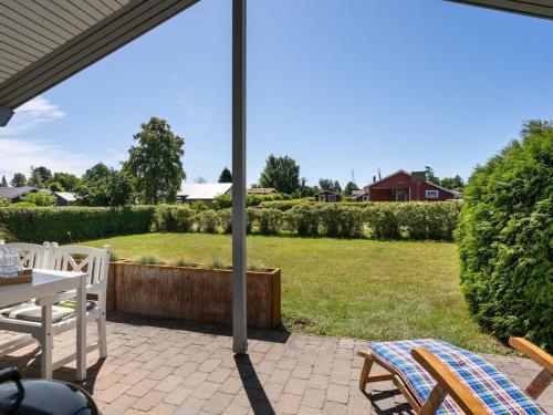 a patio with a table and chairs and an umbrella at Holiday Home Ilppo - 200m from the sea by Interhome in Hesselager