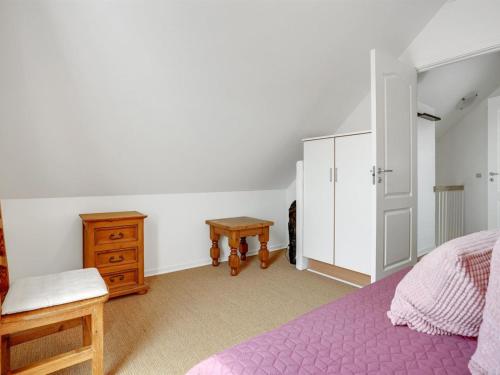 a bedroom with a purple bed and a wooden dresser at Holiday Home Askan - 200m from the sea by Interhome in Bro
