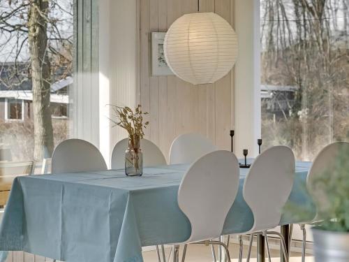 a dining room with a blue table and white chairs at Holiday Home Kalle - 400m from the sea by Interhome in Hårby