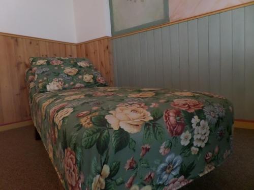 a bedroom with a bed with a floral bedspread at Hotel Miramonti in Schio