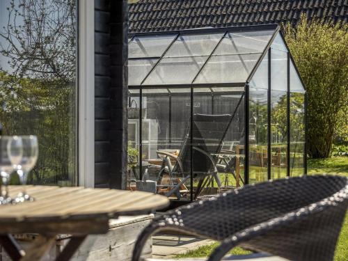 a glass house with a table and chairs on a patio at Holiday Home Ylvie - 150m from the sea by Interhome in Frørup