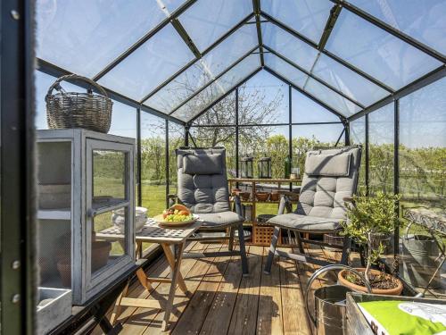 a greenhouse with two chairs and a table at Holiday Home Ylvie - 150m from the sea by Interhome in Frørup
