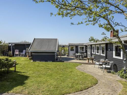 a tiny house with a patio and a yard at Holiday Home Ylvie - 150m from the sea by Interhome in Frørup