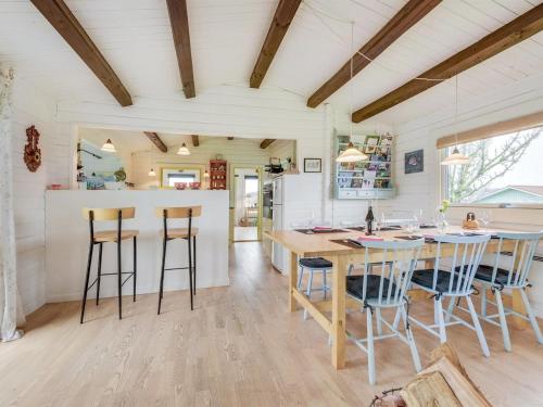 a kitchen with a wooden table and stools at Holiday Home Ylvie - 150m from the sea by Interhome in Frørup