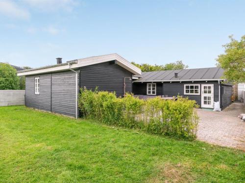 a black house with a garden in front of it at Holiday Home Gunlef - 50m from the sea by Interhome in Svendborg