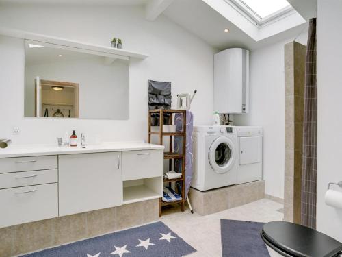 a bathroom with a sink and a washing machine at Holiday Home Gunlef - 50m from the sea by Interhome in Svendborg
