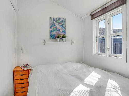 a white bedroom with a bed and a window at Holiday Home Loella - 35m from the sea by Interhome in Svendborg