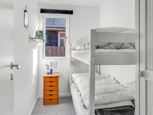a bedroom with two bunk beds and a window at Holiday Home Loella - 35m from the sea by Interhome in Svendborg