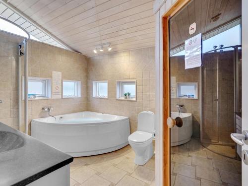 a bathroom with a tub and a toilet and a sink at Holiday Home Stefanka - 600m from the sea by Interhome in Spodsbjerg