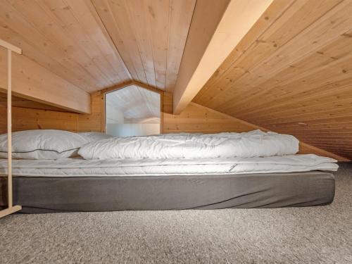 a bed in a room with a wooden ceiling at Holiday Home Stefanka - 600m from the sea by Interhome in Spodsbjerg