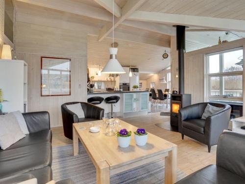 a kitchen and living room with a table and chairs at Holiday Home Stefanka - 600m from the sea by Interhome in Spodsbjerg