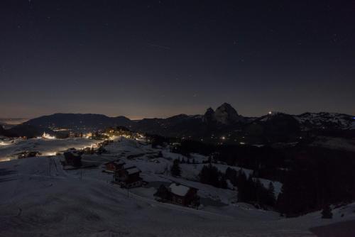 a night view of a mountain with snow and lights at Stoos Hüttä in Stoos