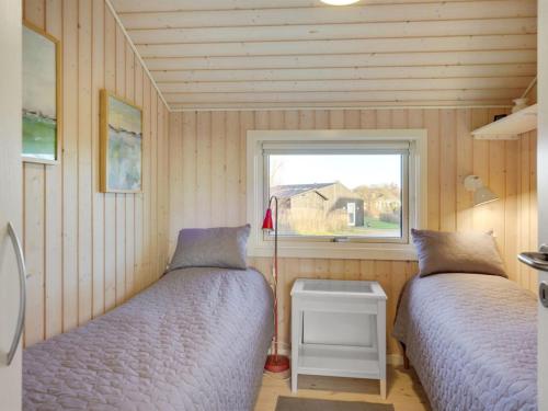 two beds in a small room with a window at Holiday Home Kulben - 450m from the sea by Interhome in Frørup