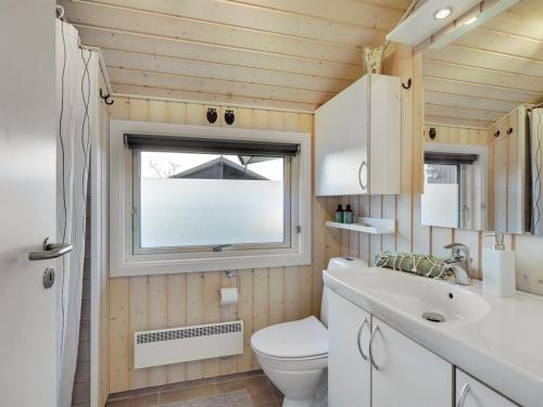 a bathroom with a toilet and a sink and a window at Holiday Home Kulben - 450m from the sea by Interhome in Frørup