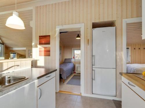 a kitchen with a white refrigerator and a bedroom at Holiday Home Kulben - 450m from the sea by Interhome in Frørup