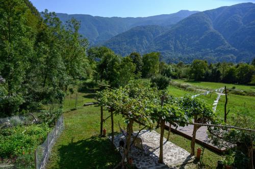 a garden with trees and mountains in the background at Stara Hiša in Log Čezsoški