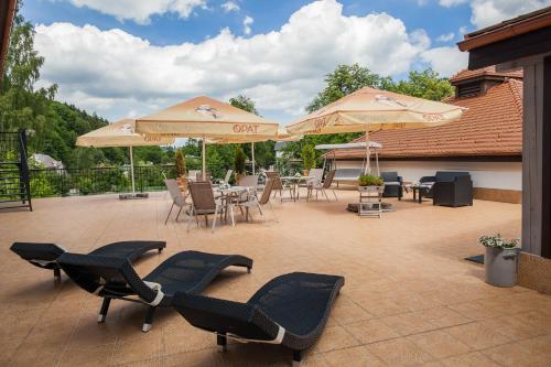 a patio with chairs and tables and umbrellas at Medical Wellness & SPA Werona in Duszniki Zdrój
