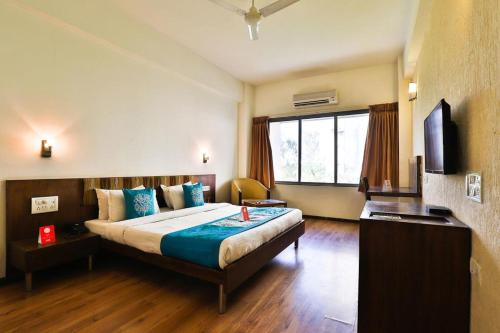 a hotel room with a bed and a window at Hotel President Inn, Gandhinagar in Gandhinagar