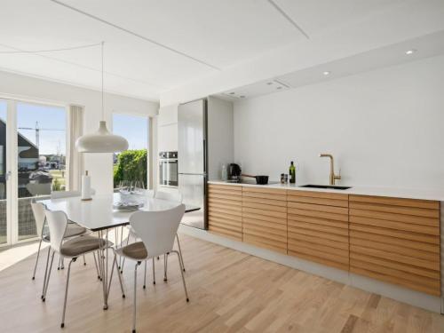 a kitchen and dining room with a table and chairs at Apartment Ninne - 50m from the sea by Interhome in Assens