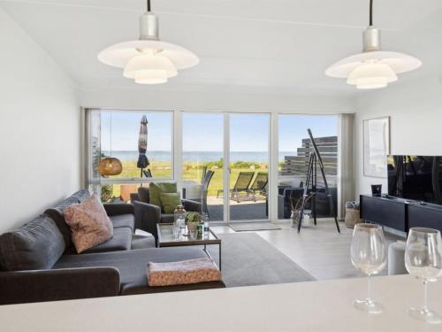 a living room with a couch and a table with wine glasses at Apartment Ninne - 50m from the sea by Interhome in Assens