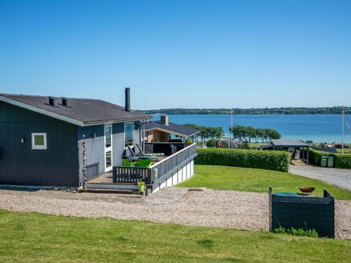 une petite maison avec un porche et une vue sur l'eau dans l'établissement Holiday Home Jenvold - 300m to the inlet by Interhome, à Åbenrå