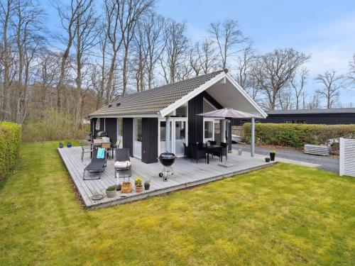 a small house with a deck in a yard at Holiday Home Gunholm - 150m from the sea by Interhome in Haderslev