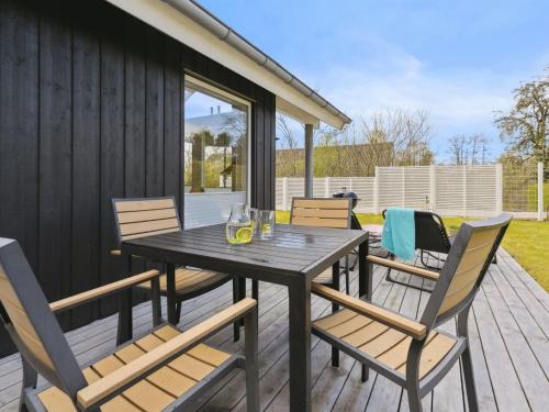 a wooden table and chairs on a deck at Holiday Home Gunholm - 150m from the sea by Interhome in Haderslev