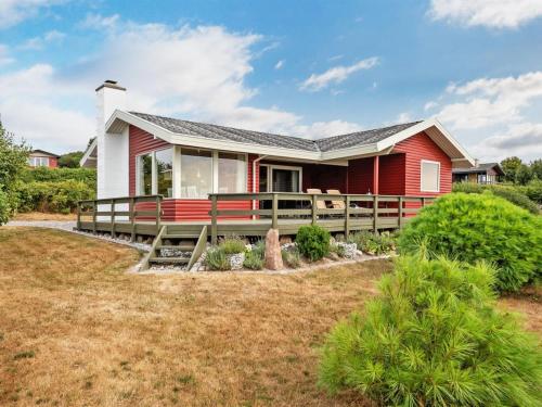 a red and white house with a large deck at Holiday Home Miriam - 300m from the sea by Interhome in Ebberup