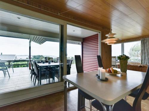a dining room with a table and a large window at Holiday Home Miriam - 300m from the sea by Interhome in Ebberup