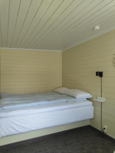 a bed in a room with a yellow wall at Lillebu in Strand