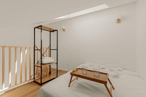 La Celle-sous-GouzonにあるL'Oasis de Décinesのベッドとテーブルのある白い部屋
