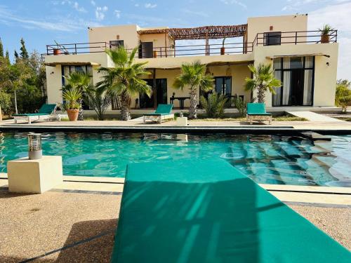a villa with a swimming pool in front of a house at La Perle d'Argan in Essaouira