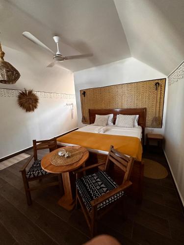 a bedroom with a bed and a table and chairs at Juana Ocean Villas in Makunduchi