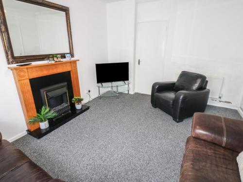 a living room with a couch and a chair and a television at Georgian Town House in Whitehaven