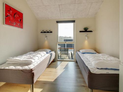 a row of beds in a room with a window at Holiday Home Yakari - 300m from the sea by Interhome in Haderslev