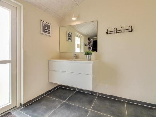 a bathroom with a sink and a mirror at Holiday Home Yakari - 300m from the sea by Interhome in Haderslev
