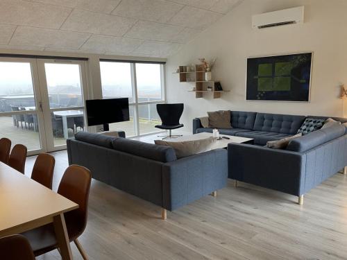 a living room with two couches and a tv at Holiday Home Yakari - 300m from the sea by Interhome in Haderslev