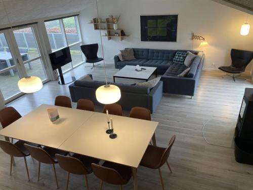 a living room with a couch and a table and chairs at Holiday Home Yakari - 300m from the sea by Interhome in Haderslev