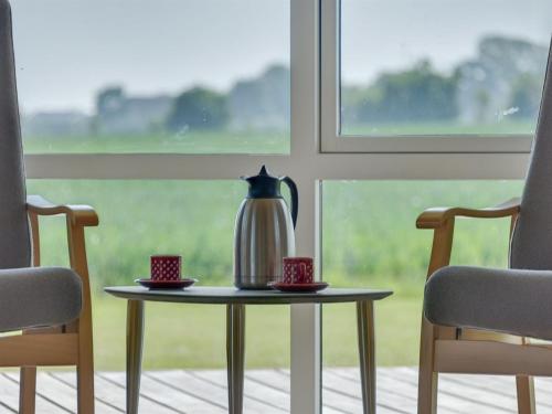 a tea kettle on a table in front of a window at Holiday Home Iorund - 550m from the sea by Interhome in Haderslev