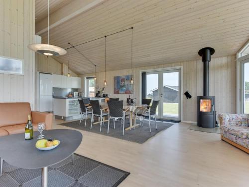 a living room and kitchen with a table and a fireplace at Holiday Home Iorund - 550m from the sea by Interhome in Haderslev