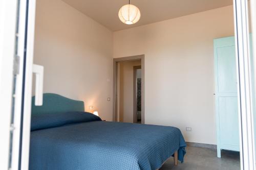 a bedroom with a bed with a blue blanket at Vigne Marrone B&B in Fossacesia