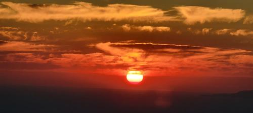 a sunset with the setting sun in the clouds at Alonia Studios in Firostefani