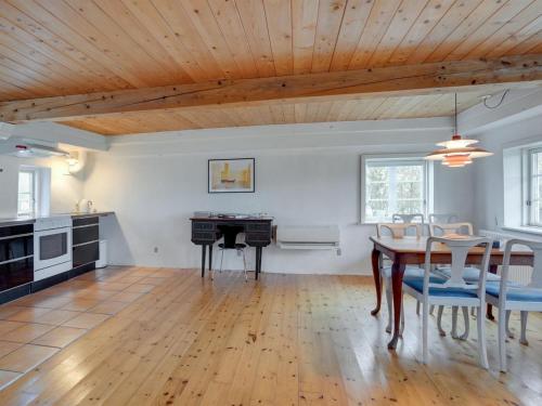 a kitchen and dining room with a wooden ceiling at Holiday Home Aughe - 25km from the sea by Interhome in Bredebro