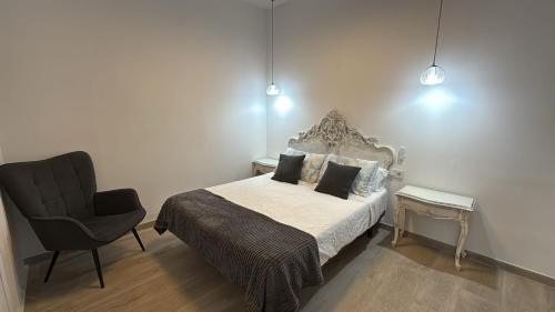 un dormitorio con una cama y una silla en Salabert Suite, en Valencia