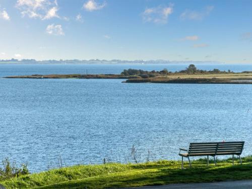 BroagerにあるHoliday Home Nica - 100m from the sea by Interhomeの大きな水の横に座るベンチ