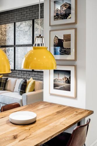 a dining room with a table and a yellow lamp at Midtown Apartments in Barcelona