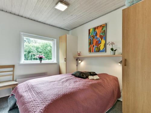 a bedroom with a bed with a pink blanket and a window at Holiday Home Locan - 1-2km from the sea by Interhome in Humble
